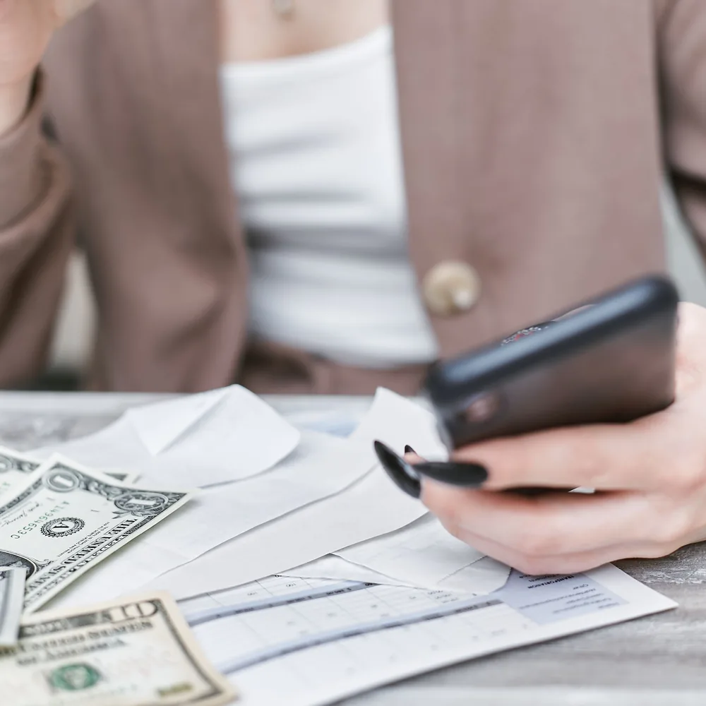 Creadora revisando en el celular cómo cobrar OnlyFans en Argentina